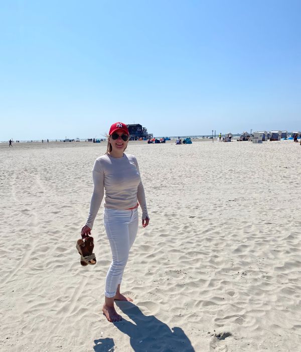 Blonde Frau steht am Strand