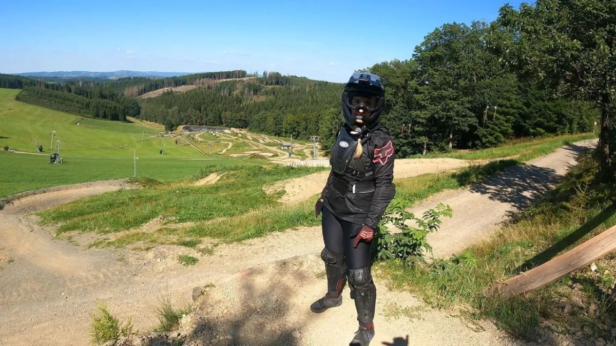 Mountainbike Fahrerin in schwarzer Kleidung steht im Bikepark Olpe