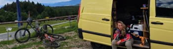 Vanesssa sitzt nach nach einem Bikepark Tag im Van und isst für ihre Mountainbike Regeneration