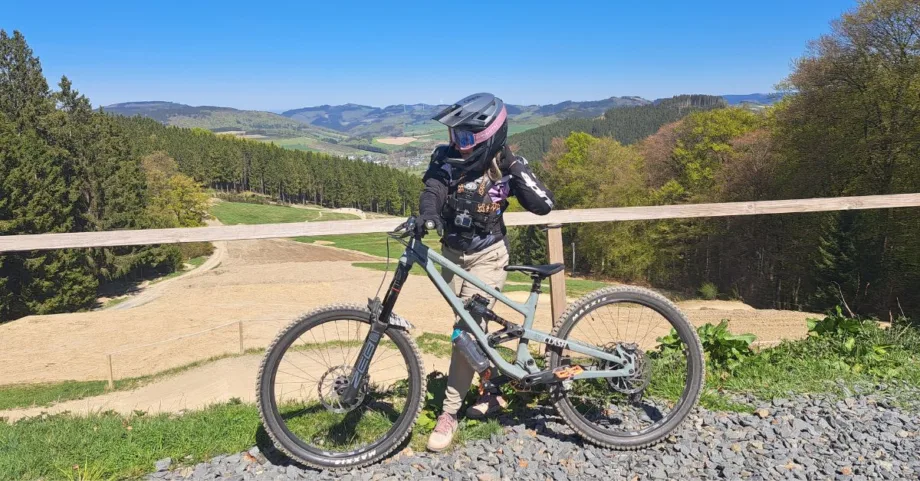 Vanessa steht im Green Hill Bikepark und trägt ihre Bikepark Kleidung